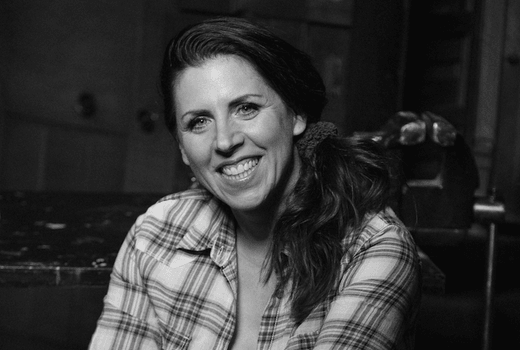 Frau mit kariertem Hemd lächelt in Werkstatt für Schönes in Düsseldorf, DIY-Workshop-Dozentin