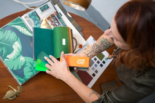 Frau mit Tattoo wählt Farbmuster für Interior Design Workshop in der Werkstattfürschönes Düsseldorf aus.