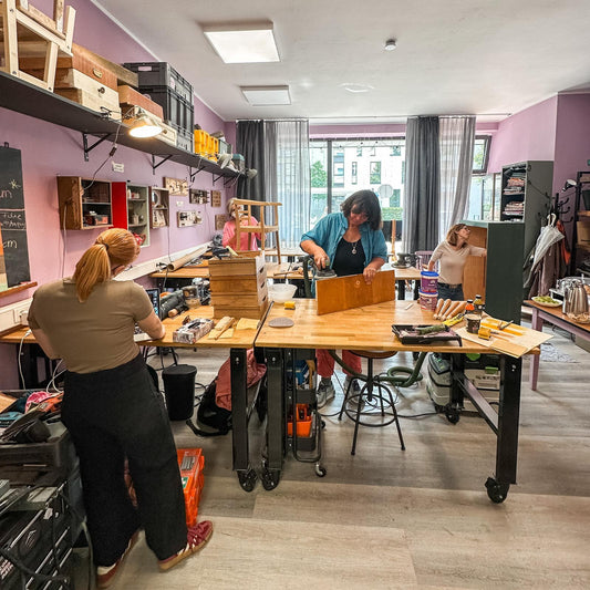 Werkstattfürschönes Möbel-Workshop in Düsseldorf, Teilnehmerinnen bearbeiten Holzmöbel an Werkbänken