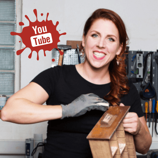 Frau in Werkstatt für Schönes in Düsseldorf schleift Holz, YouTube-Logo im Hintergrund, DIY Workshop