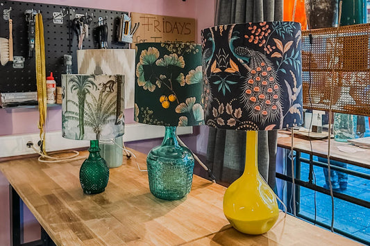 Drei bunte Lampenschirme mit Vintage-Mustern auf Werkbank in kreativer Werkstatt für Schönes Düsseldorf