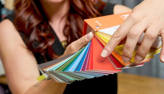 Frau zeigt Farbfächer in Werkstatt für Schönes in Düsseldorf für DIY-Workshops und Möbelaufarbeitung