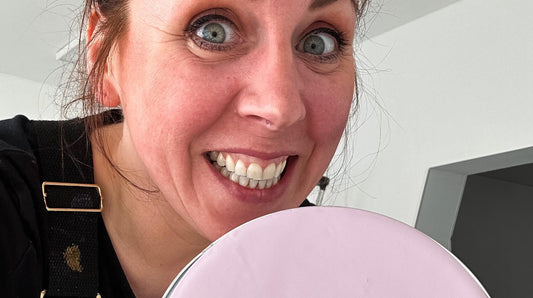 Lächelnde Frau in Werkstatt für Schönes Düsseldorf mit rosa DIY-Objekt, Nahaufnahme